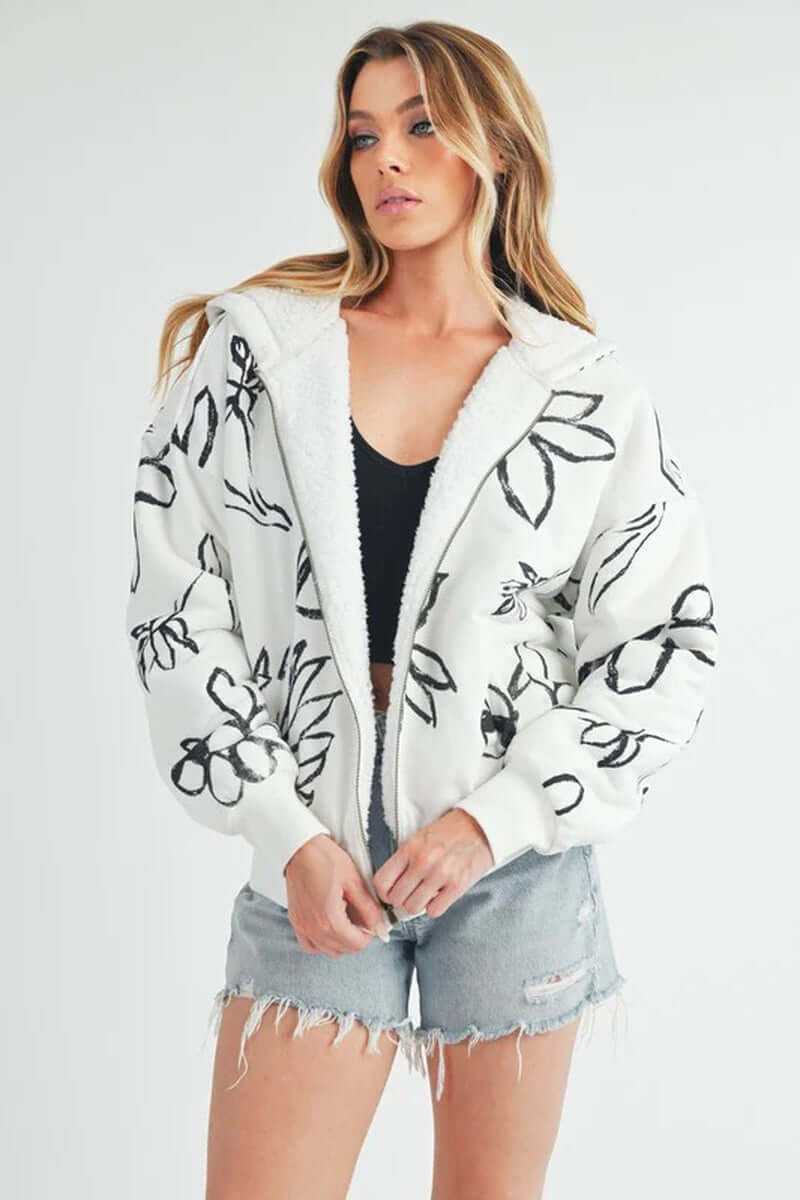 Model wearing the Oita Jacket, a cozy bomber-style jacket with floral print and soft sherpa lining.