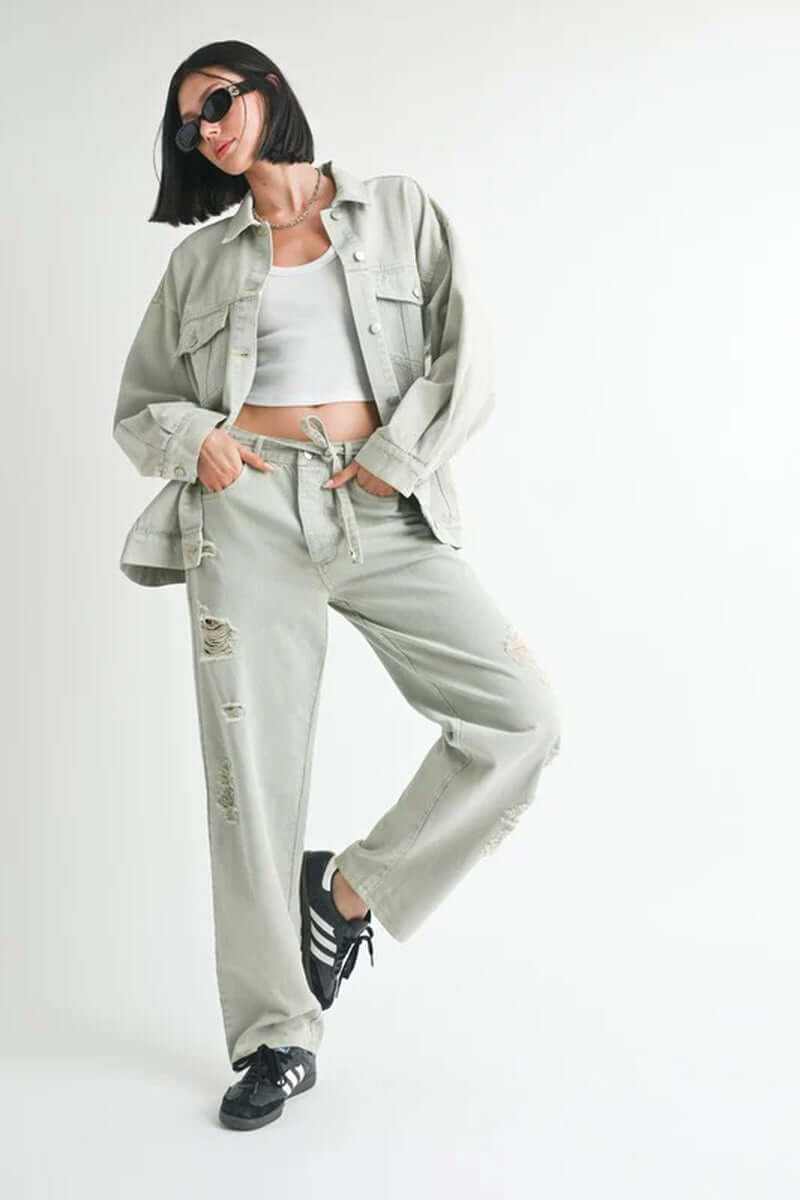 Model showcasing oversized denim jacket paired with ripped wide-leg pants and sneakers, perfect for a fashionable casual look.
