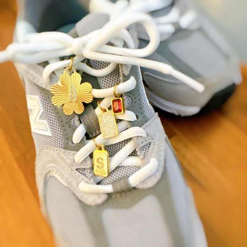 Personalized Lucky Clover Initial Seamless Charm Clip on sneaker laces, showcasing gold charms and stylish design.