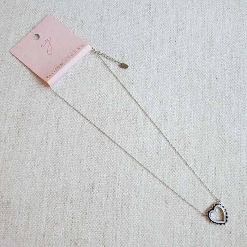 Preciously scallop edged heart necklace with 18k gold plating, featuring a unique stylish design on a soft background.