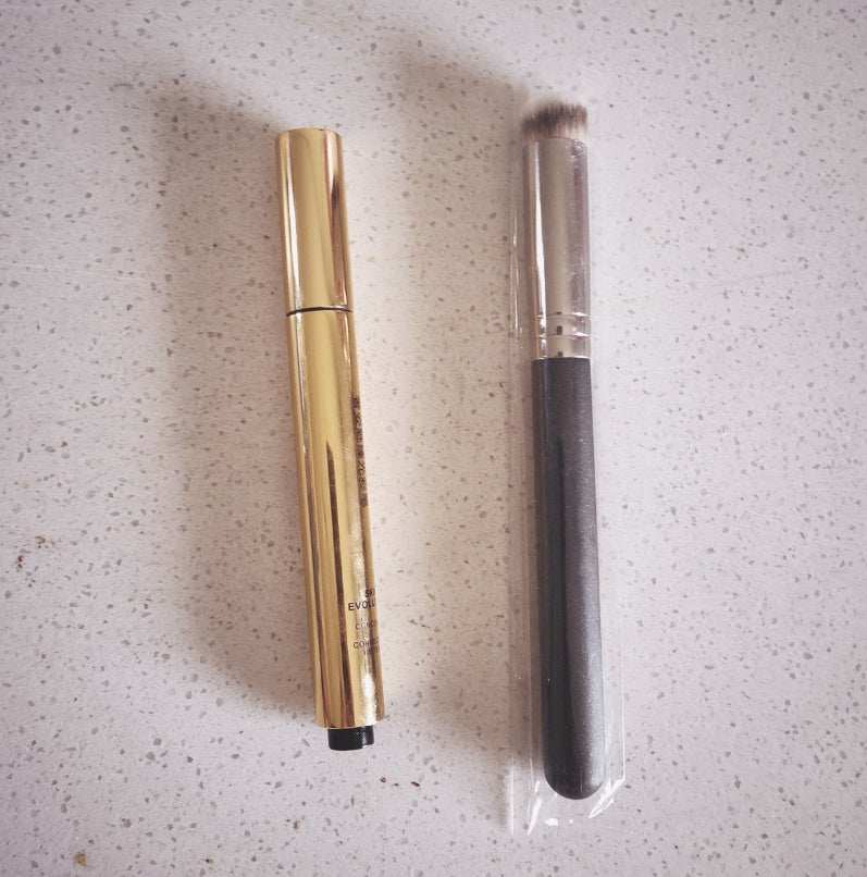 Revitalizing Acne & Pigmentation Cream concealer pen and brush set on speckled surface
