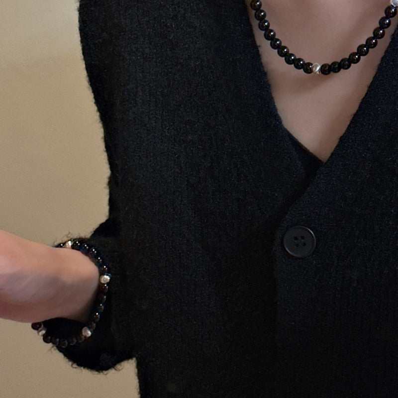 Sterling silver black agate cat's eye bracelet and necklace set on woman wearing black sweater