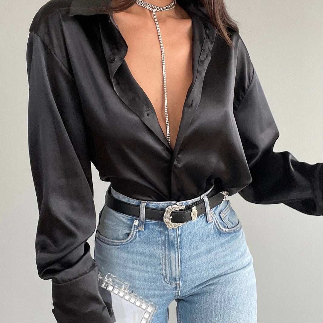 Black long sleeve lapel shirt for women, styled with denim and a chic accessory.