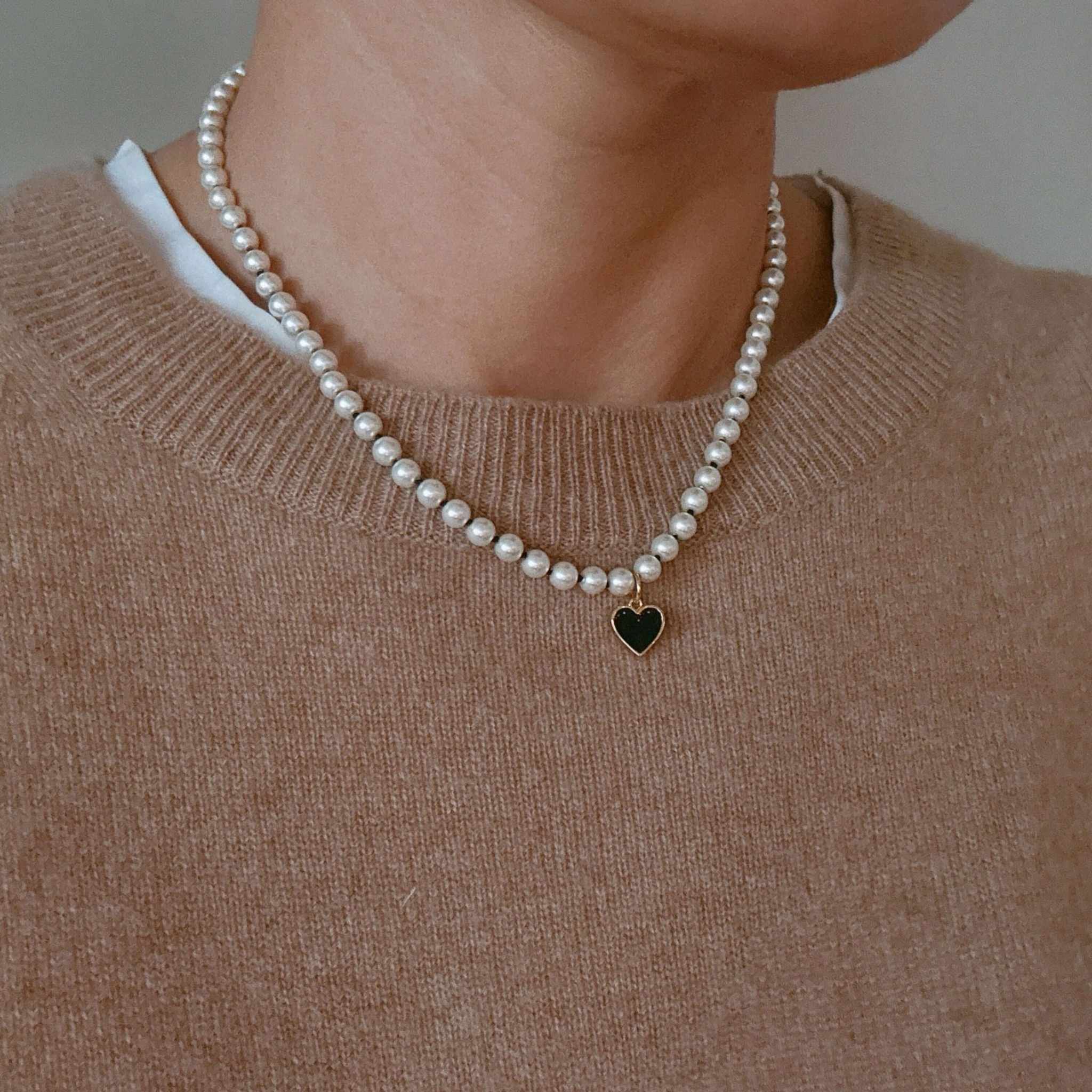 Silky adjustable thread heart pendant necklace featuring pearls and a heart charm, worn on a sweater.