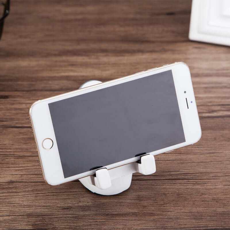 Simple astronaut mobile phone stand holding a smartphone on a wooden desk, perfect for students and cute desk decoration.