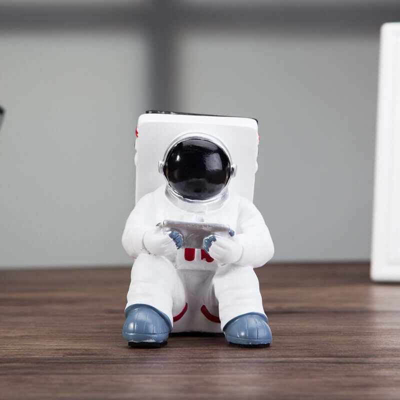 Cute astronaut mobile phone stand designed for desk use, featuring a stylish spaceman holding a smartphone.