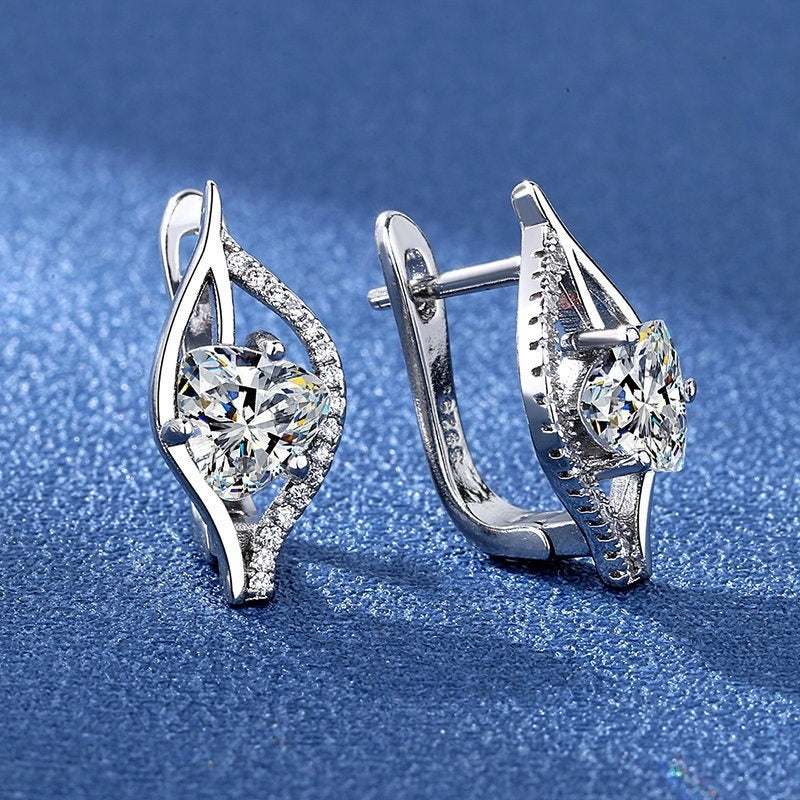 Simple and stylish silver plated earrings with heart shape and central crystal stone on blue background