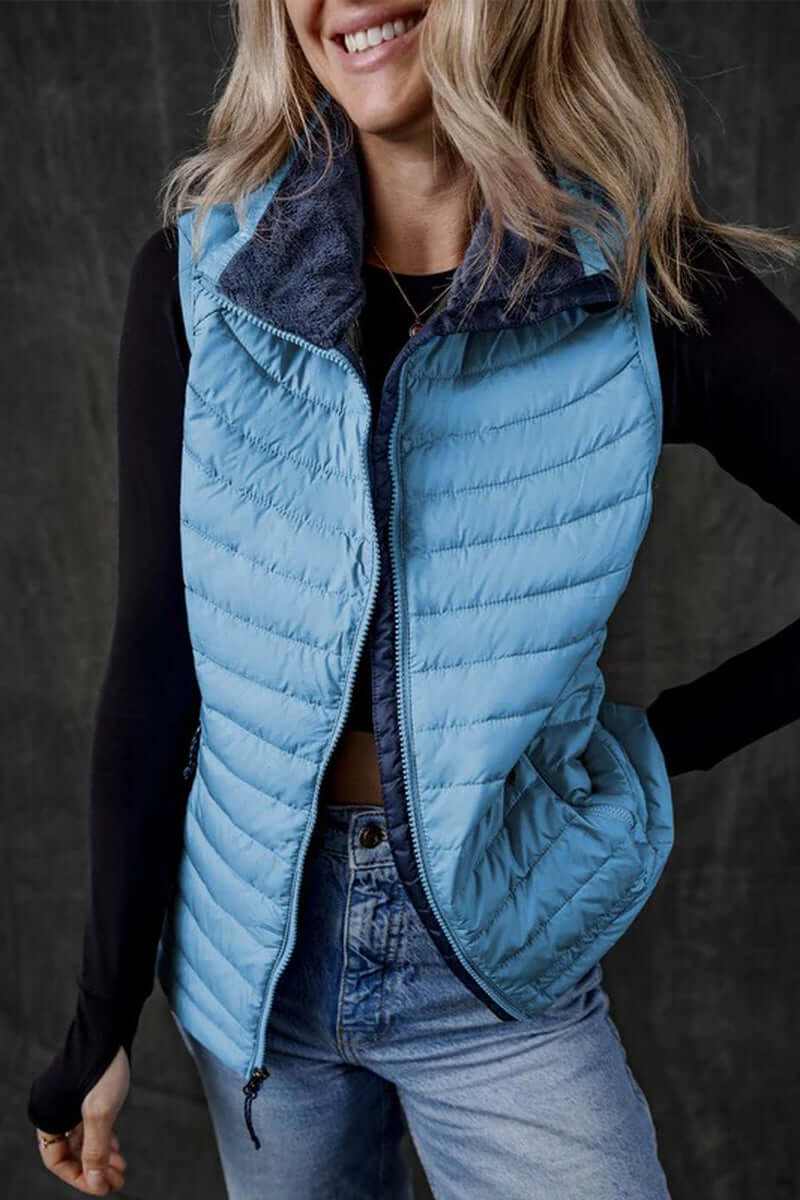 Sky blue plush collared quilted zipped puffer vest, stylish sleeveless design for warmth and layering.