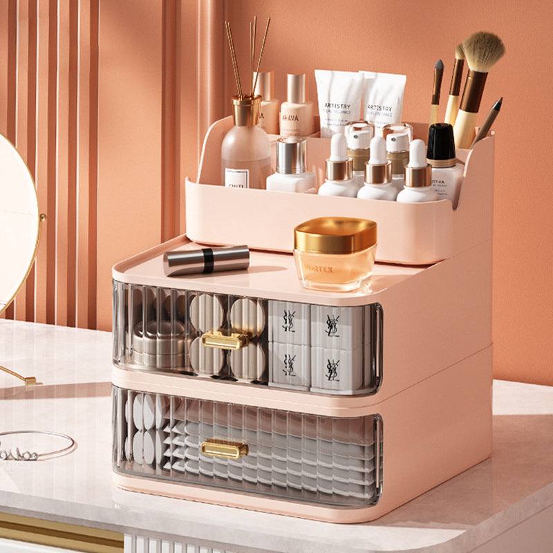 Pink space-saving vanity storage box with multiple compartments for cosmetics and makeup brushes on a white countertop