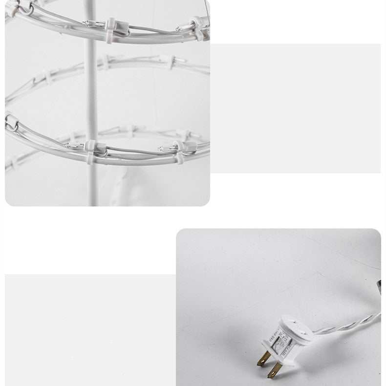 Spiral Christmas tree lights power cord and structure with circular wire frame for decoration.