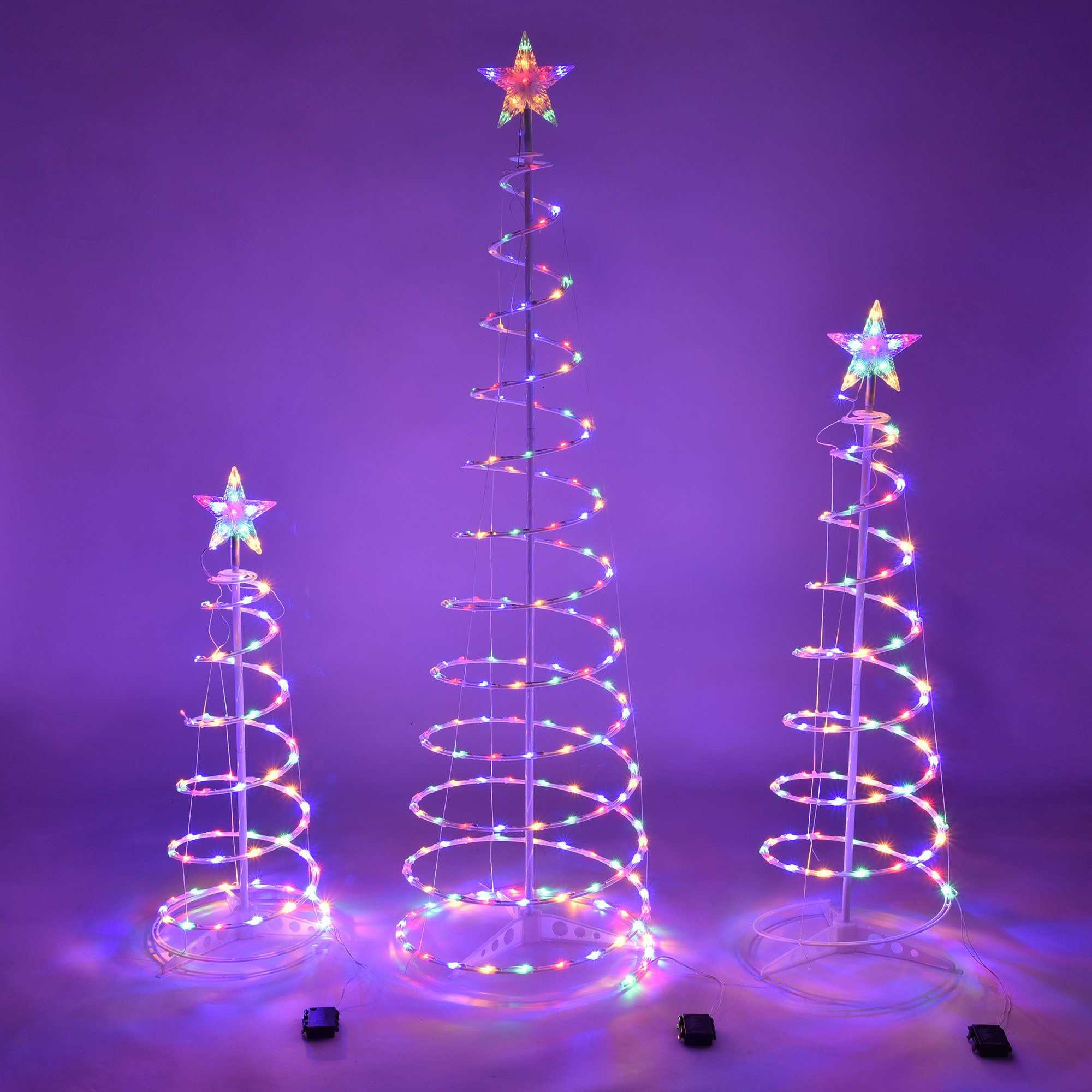 Colorful spiral Christmas tree lights displayed on three illuminated spiral trees with star toppers.