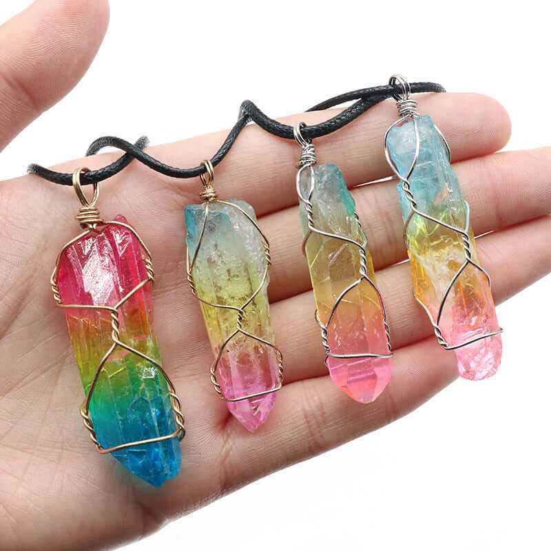 Colorful crystal pillar pendants in hand, showcasing vibrant hues and wire detailing, perfect fashion necklace accessory.
