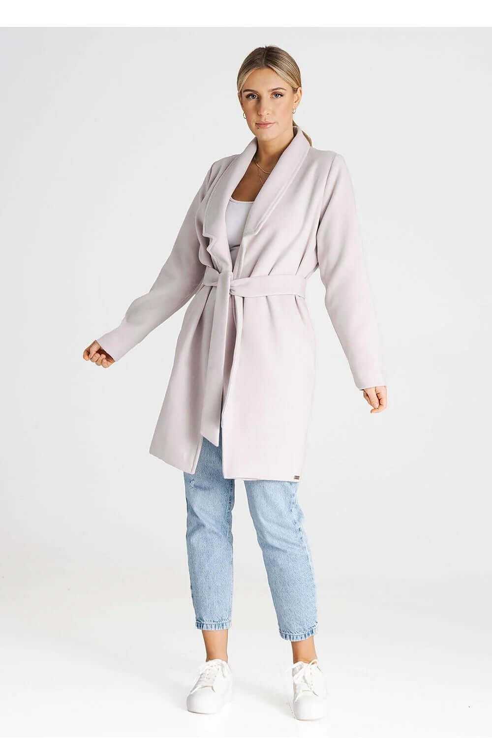 Stylish Figl double-breasted coat with a belted design, worn over casual jeans and sneakers.