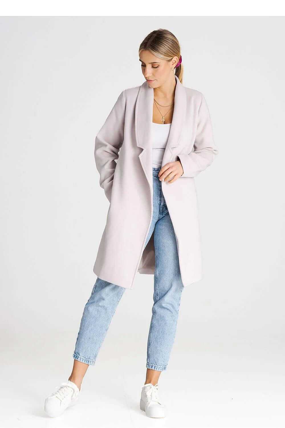 Stylish Figl double-breasted coat in soft pink, featuring a large collar and worn casually with jeans and sneakers.