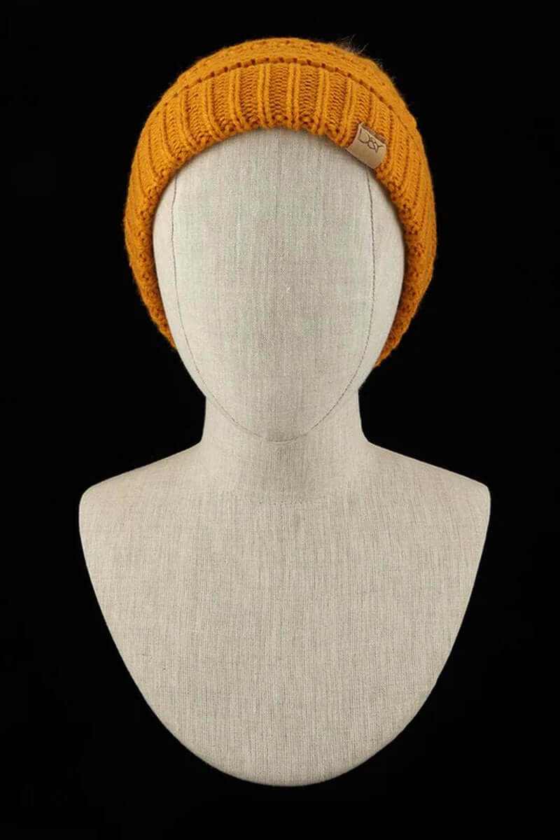 Super soft orange halo ripped faux fur pom beanie displayed on a mannequin against a black background.