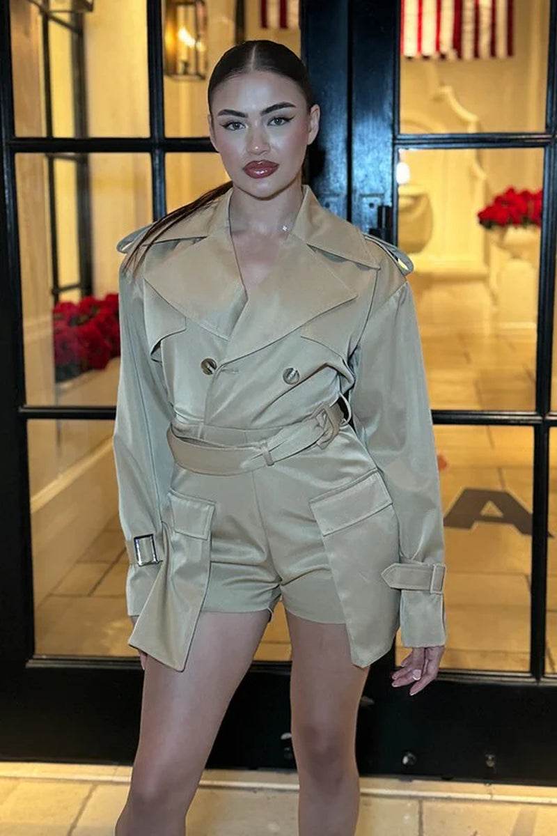 Model wearing a chic beige utility style romper with trench coat design, showcasing sophisticated fashion trends.