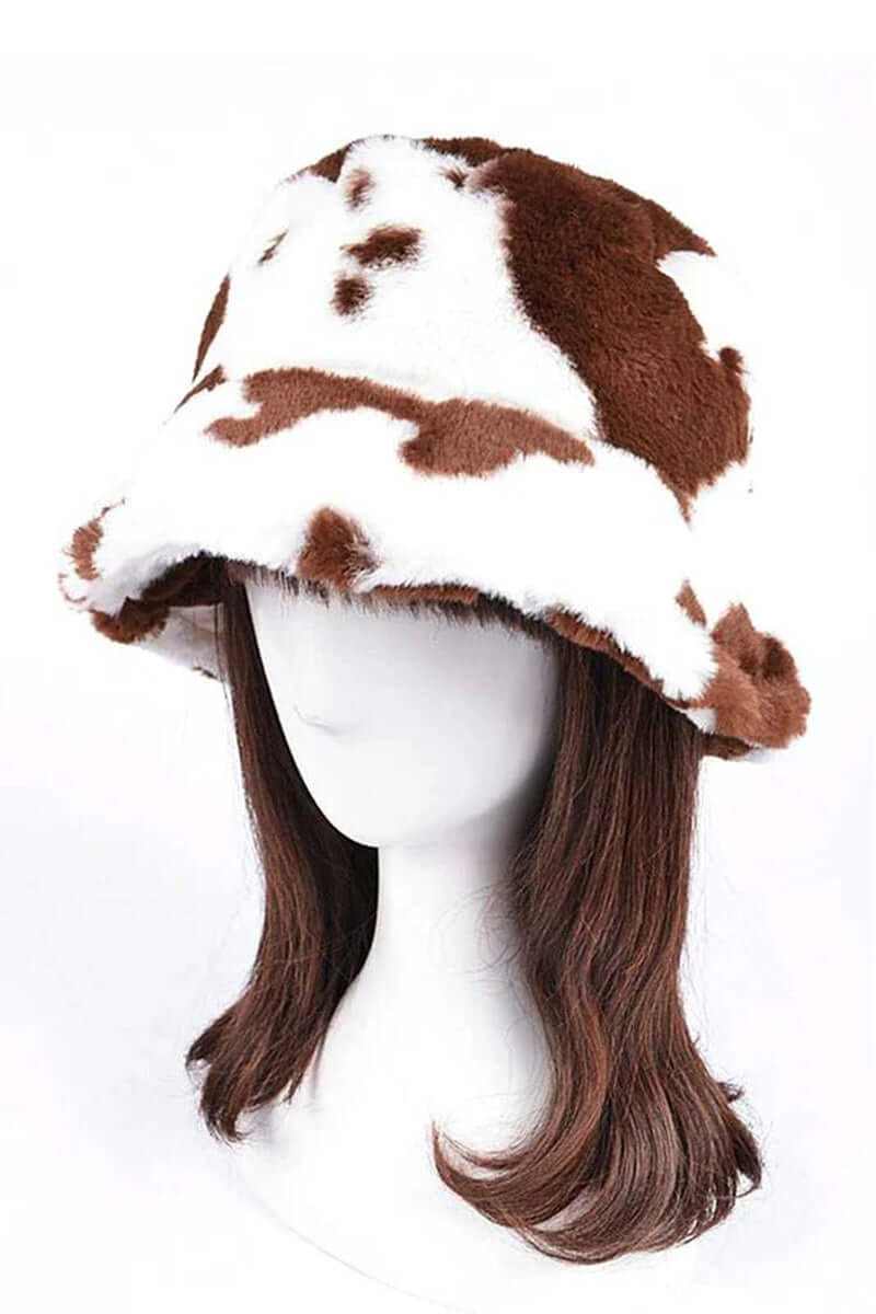 Trendy soft cow print faux fur bucket hat on mannequin, perfect for stylish winter outfits.