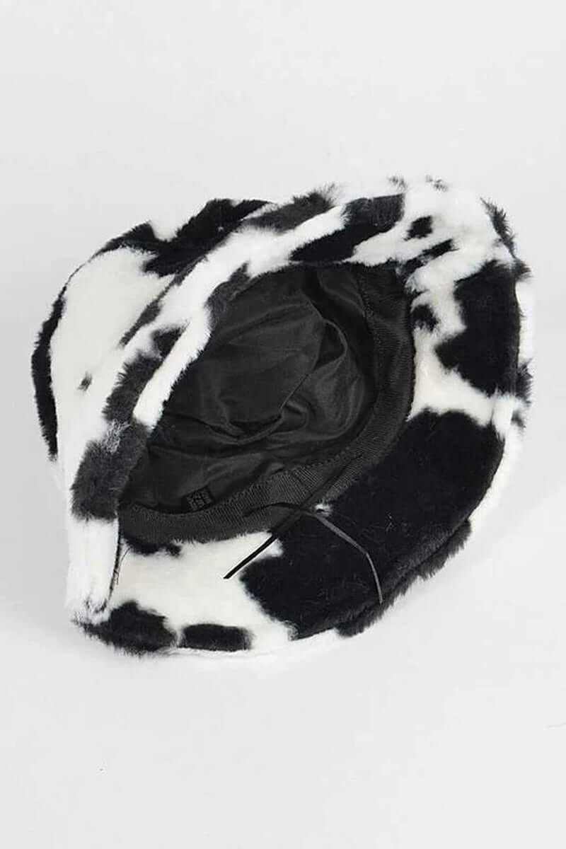 Inside view of a trendy soft cow print faux fur bucket hat, featuring a cozy black and white pattern.