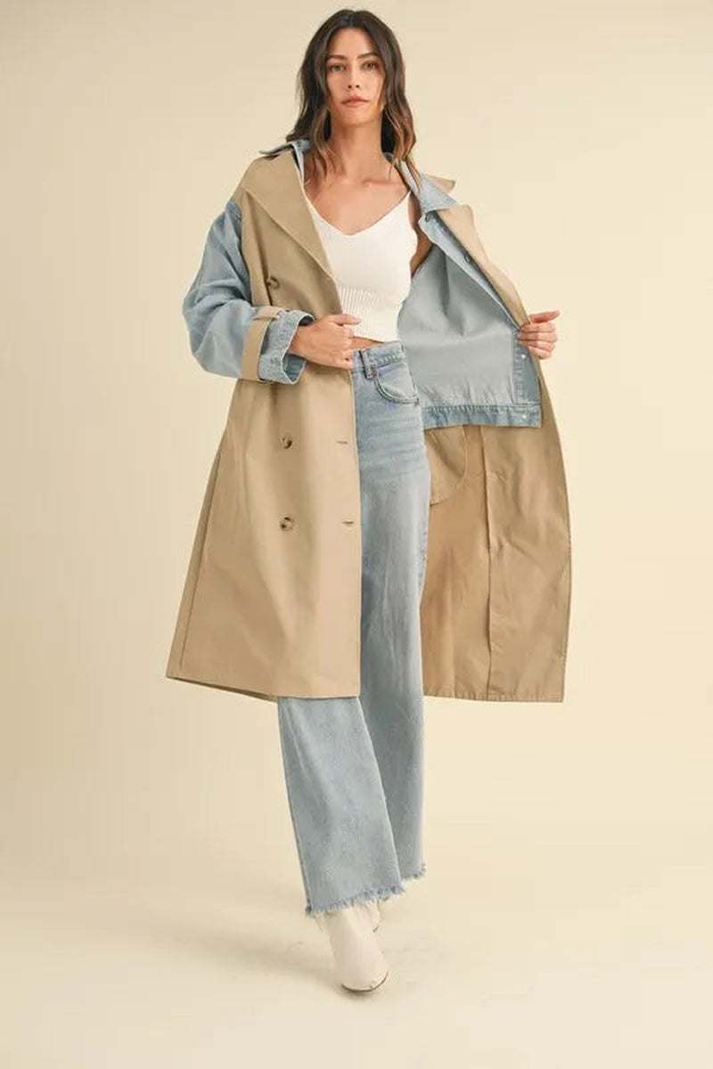 Model wearing a two-in-one MABLE layered trench coat with denim, showcasing its trendy design and versatility.