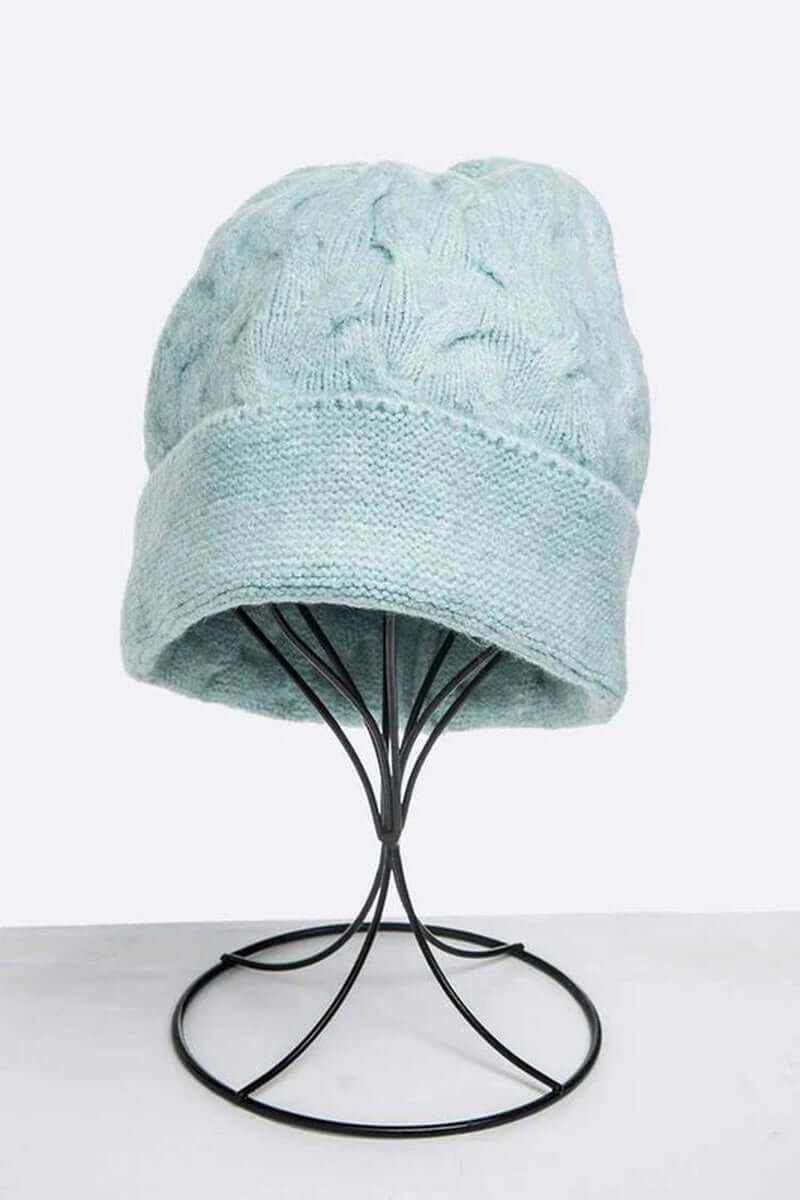 Soft knit slouchy beanie in light blue, displayed on a stand, perfect for unisex winter fashion.
