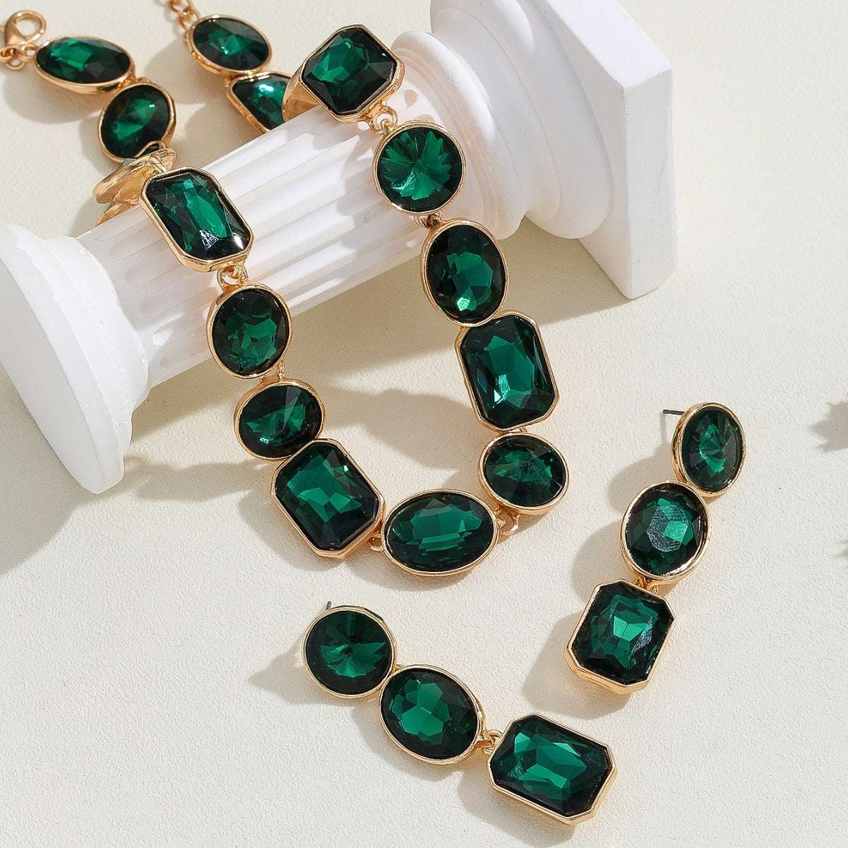 Vintage style crystal jewelry set with green gemstones and gold-tone setting including earrings and necklace