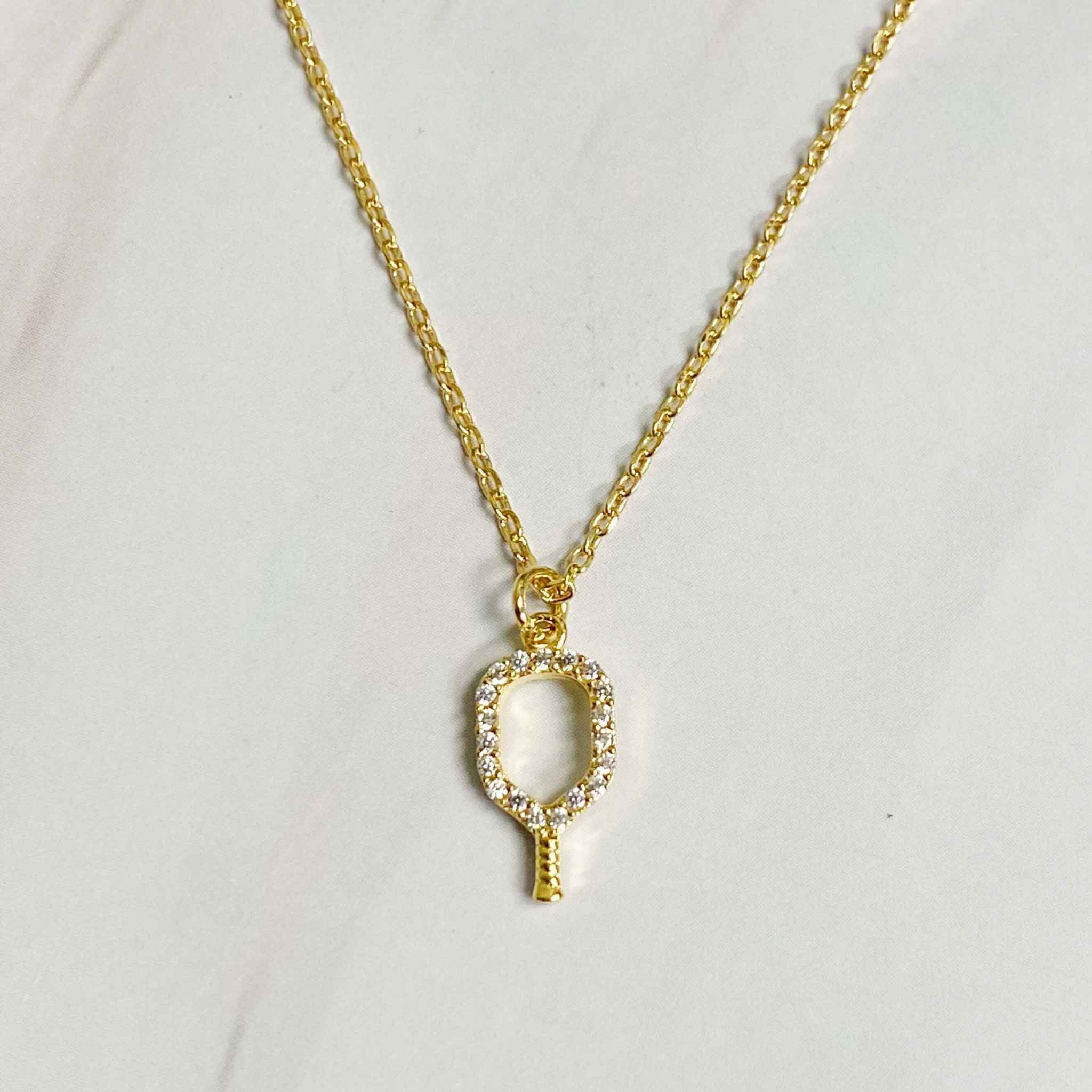 Dainty gold pickleball racket pendant necklace with sparkling details, perfect for pickleball enthusiasts.