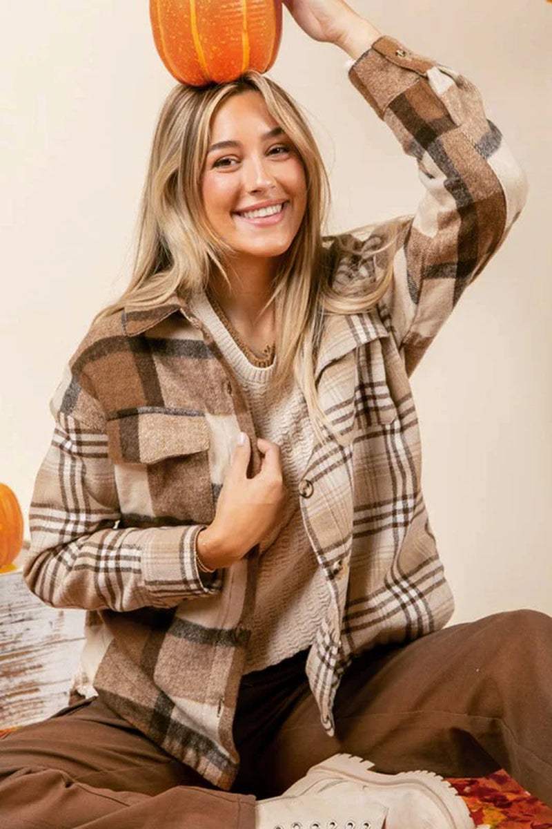 Smiling woman wearing a women flannel plaid double flap pocket jacket, holding a pumpkin, showcasing a cozy fall style.