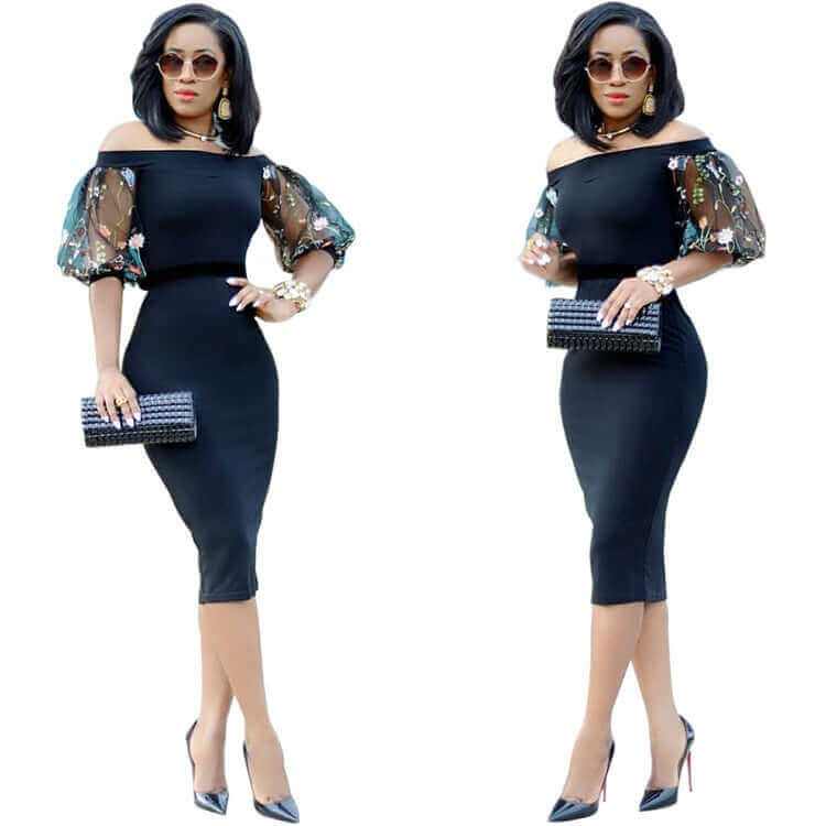 Elegant woman in a black off-the-shoulder dress with floral sleeves, accessorized with sunglasses and a clutch.