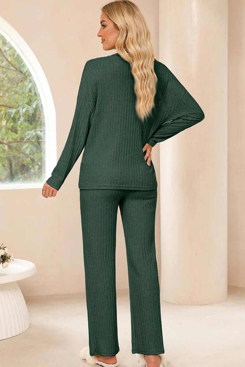 Back view of a woman in a cozy ribbed knit green V-neck two-piece outfit, showcasing slouchy fit and relaxed style.