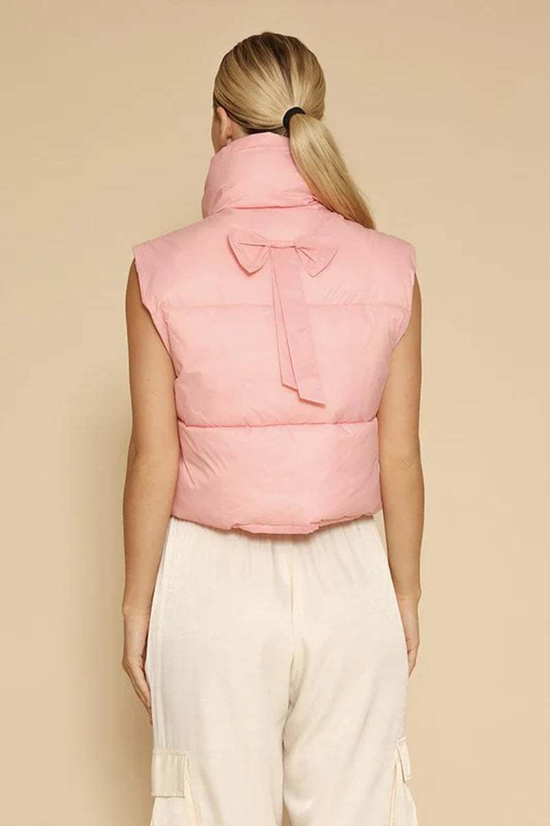 Back view of women's cropped pink puffer vest with bow detailing