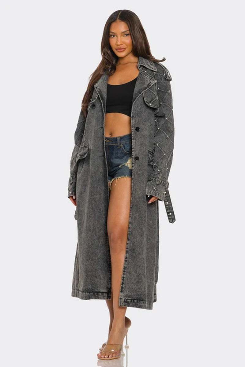 Women’s edgy distressed longline denim trench coat in faded charcoal black, paired with a crop top and denim shorts.