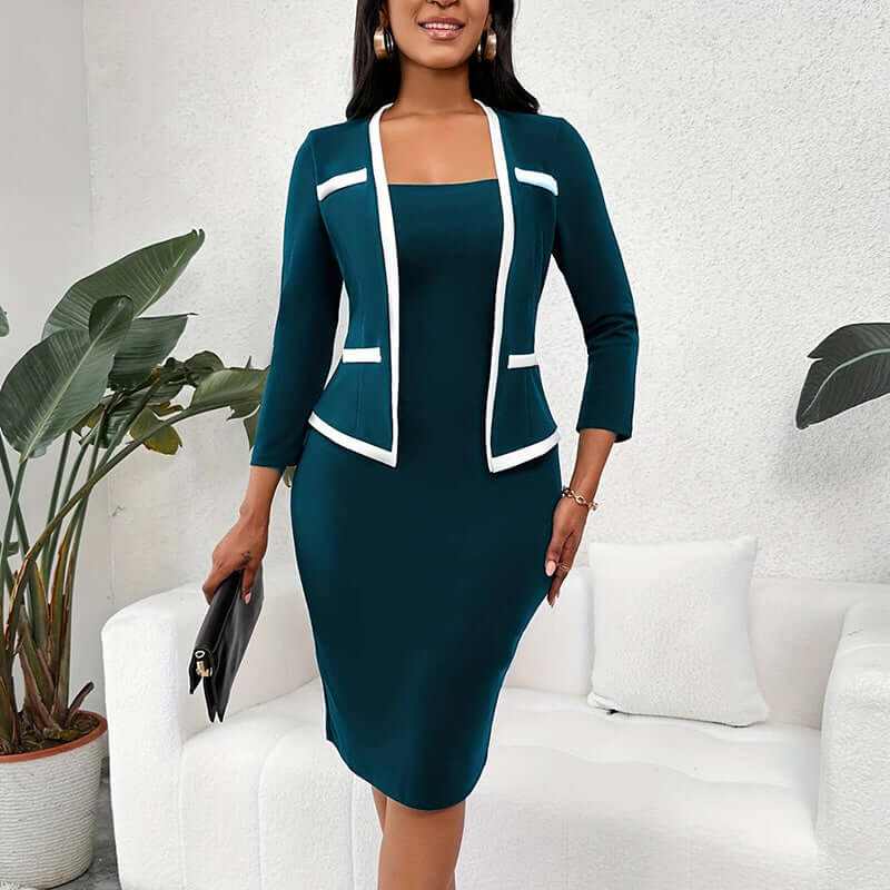 Woman wearing navy blue mock two-piece office dress with white trim and half sleeves standing indoors