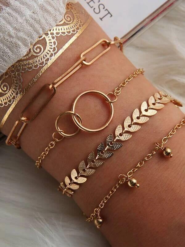 Trendy accessories collection featuring layered gold bracelets on a wrist, showcasing elegant designs and styles.