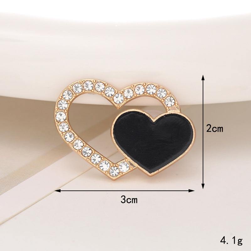 Elegant heart-shaped ornament with crystal embellishments and a black center, measuring 3cm x 2cm for stylish footwear.