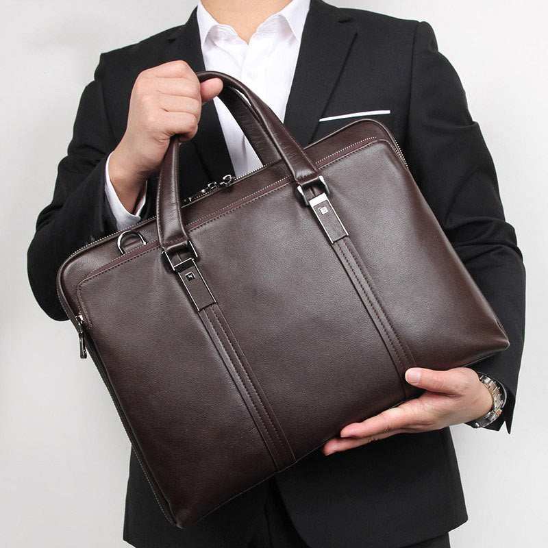 Man holding a stylish brown leather business briefcase, showcasing its premium quality and elegant design.