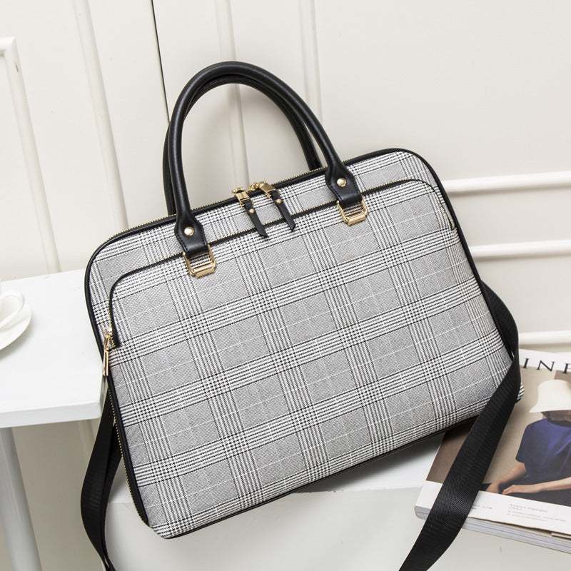 lady business laptop bag in black and white plaid design with dual handles and detachable strap.