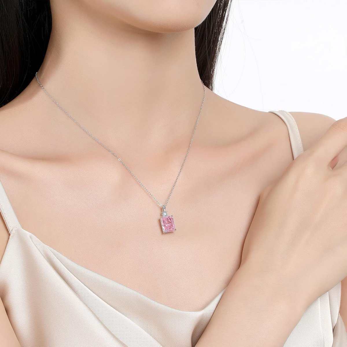 Model wearing an 18K gold plated diamond necklace with a pink imitation diamond pendant on a sterling silver chain.