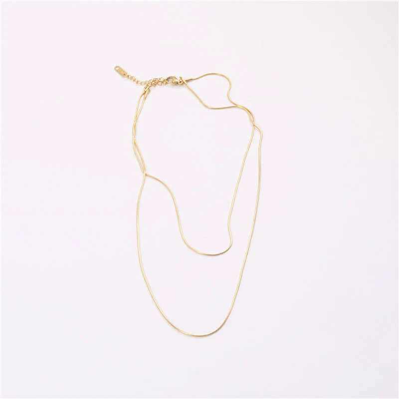 18K gold plated double-row snake chain necklace laying flat on a light background, showcasing its sleek design.