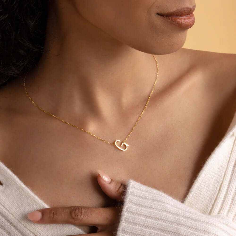 Model wearing a gold plated sideways initial letter necklace, showcasing its elegance and personalized style.