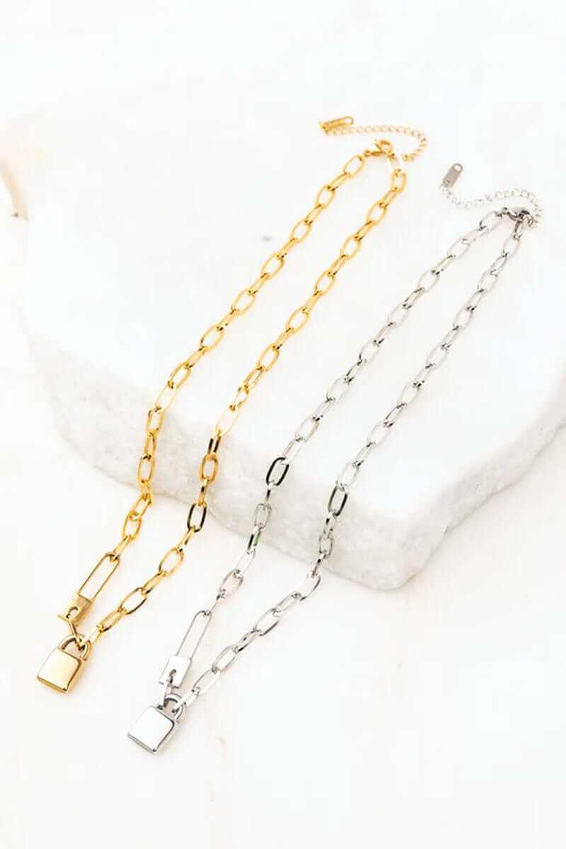18K stainless steel lock and clip chain necklace in gold and silver on marble background.