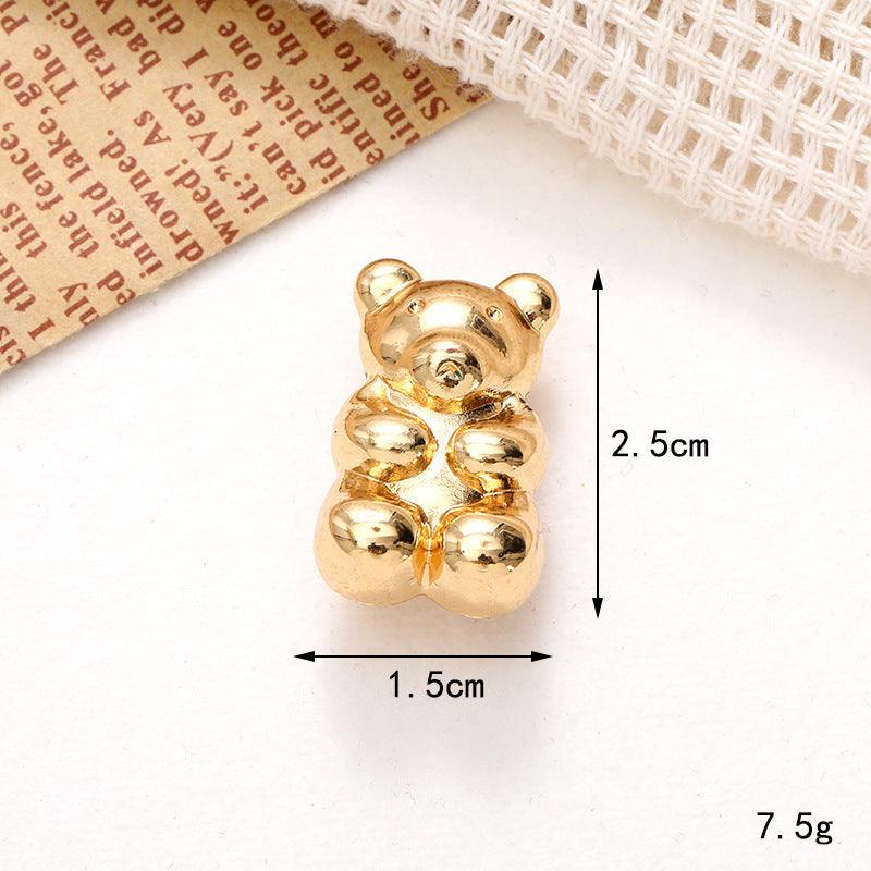 Golden teddy bear ornament measuring 2.5cm in height and 1.5cm in width, perfect for decorative purposes.