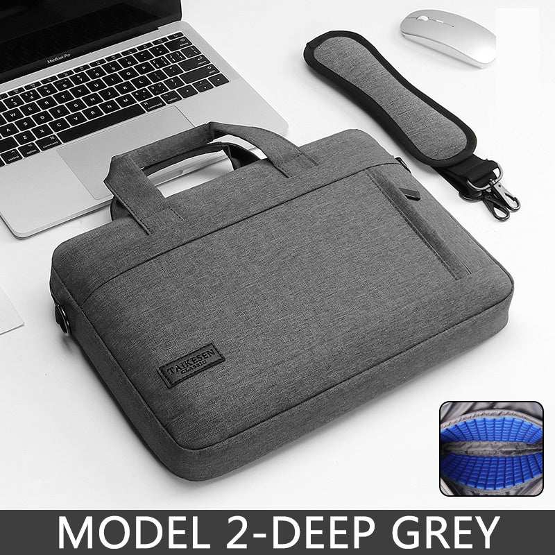 15.6 inch laptop bag in deep grey color placed on a desk next to a laptop and a mouse.