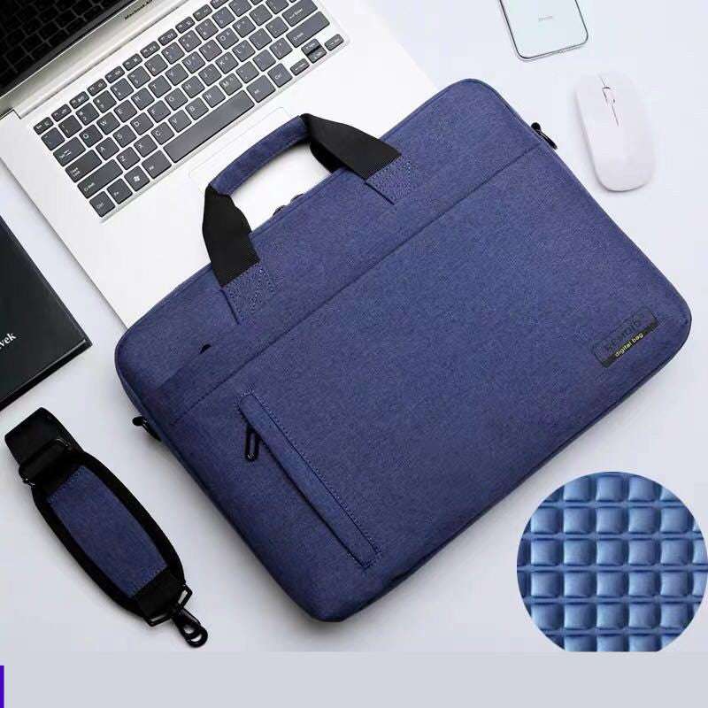 Waterproof shoulder bag for laptops displayed next to a laptop and mouse on a desk.