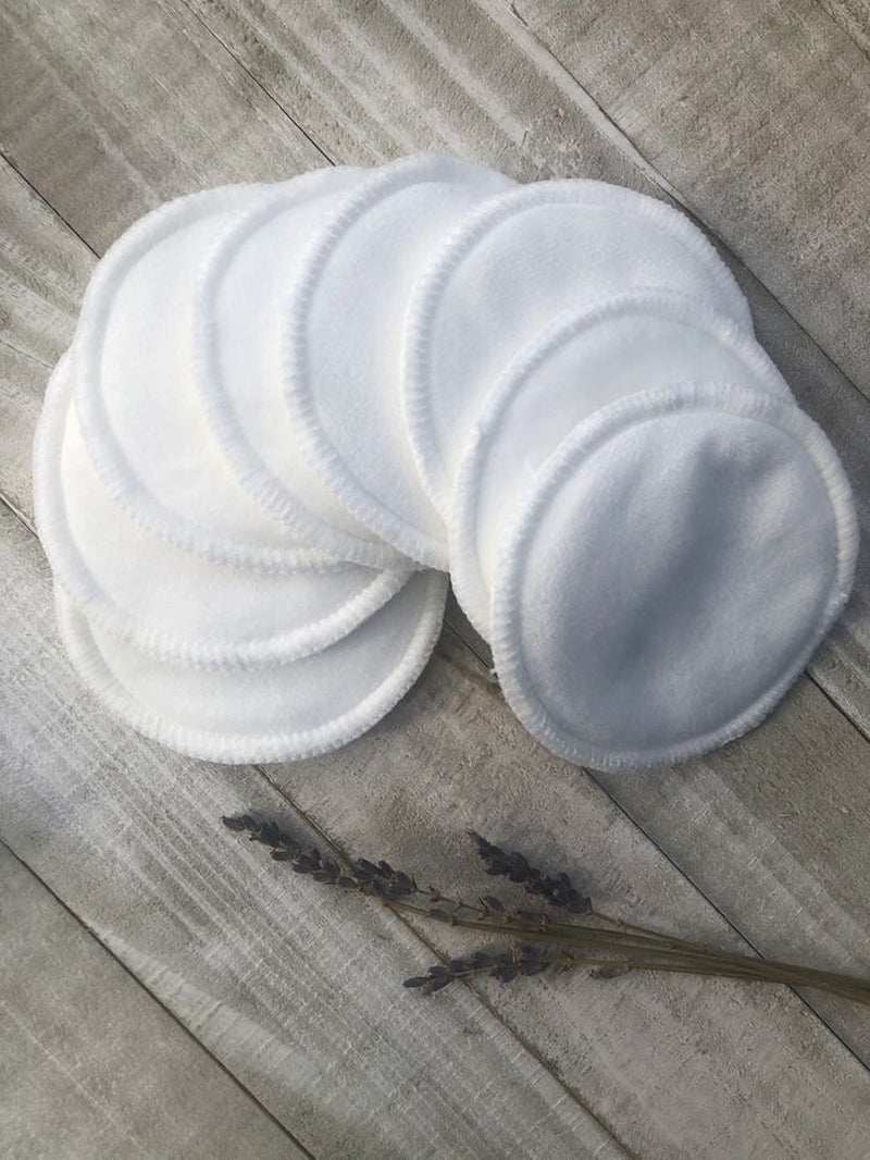 Five reusable bamboo cotton facial rounds pads stacked on wooden surface, eco-friendly for makeup removal.