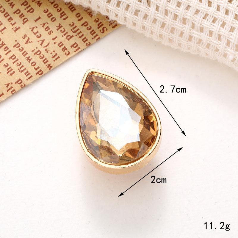Bright Pearl Flower Shoe Ornament featuring a sparkling golden crystal in a teardrop shape, measuring 2.7cm by 2cm.