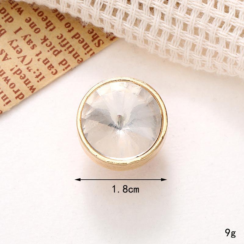 Close-up of a crystal shoe ornament, featuring a round clear gem set in a gold surround, measuring 1.8cm in diameter.