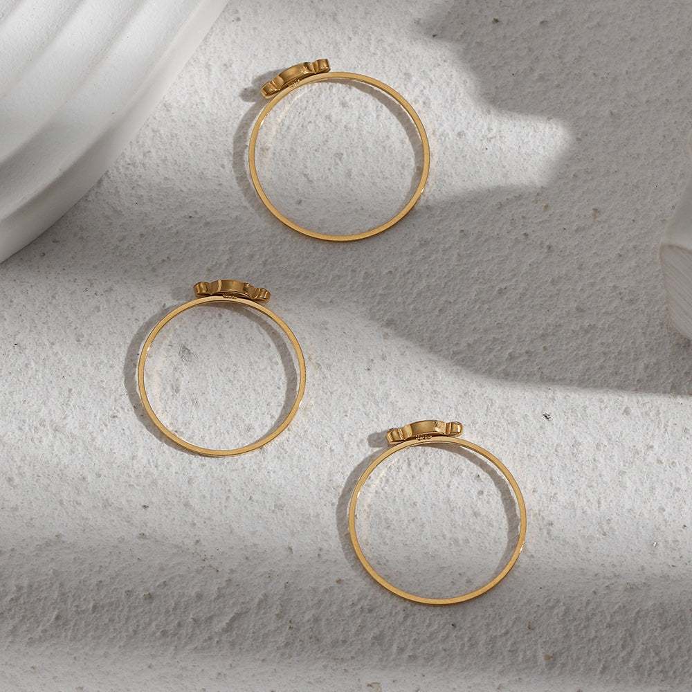 Delicate gold-plated candy-colored pearl statement rings for women on textured surface