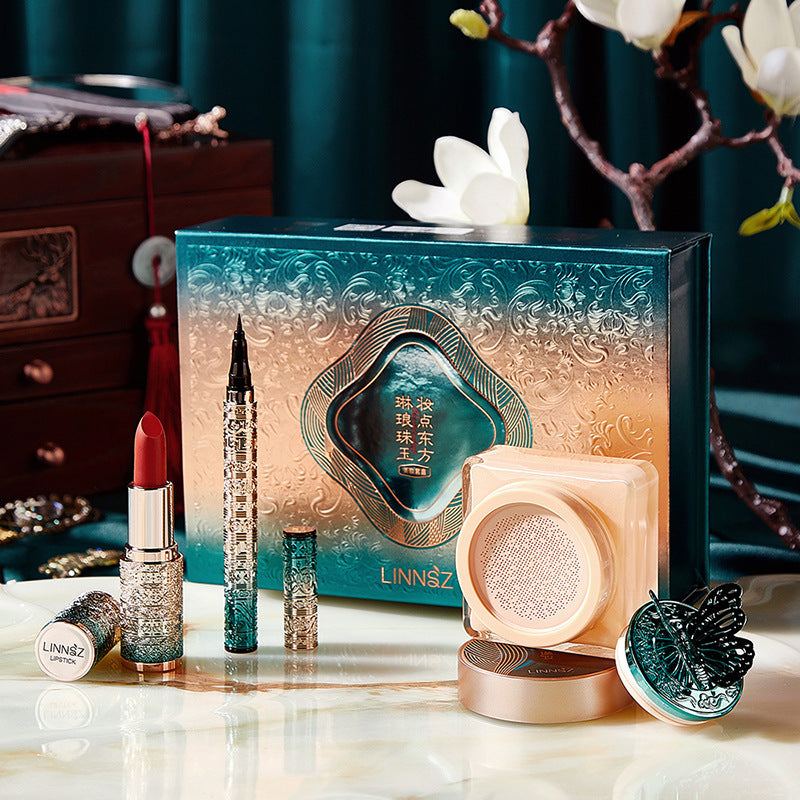 Air Cushion & Lipstick all-in-one makeup kit with ivory cream cushion, black liquid eyeliner, velvet matte lipstick, and powder puff in decorative packaging
