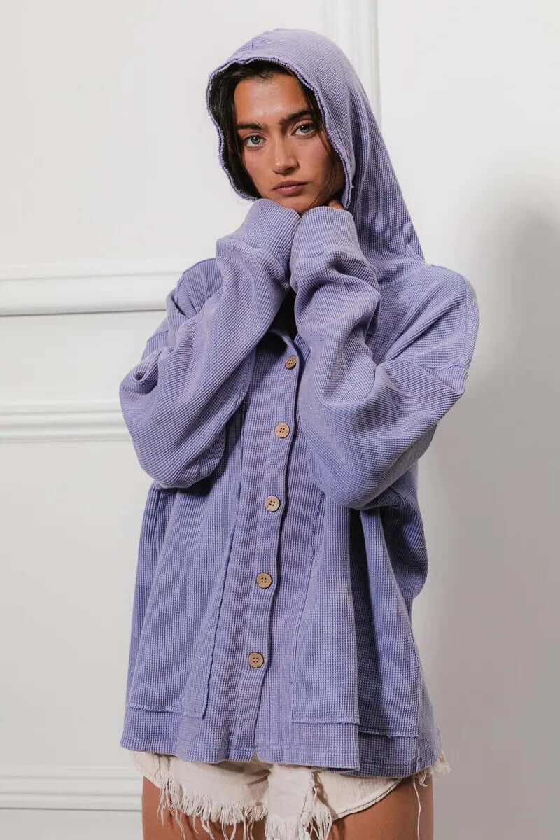 Woman wearing a purple washed waffle thermal hooded jacket, featuring a relaxed fit and button closure.