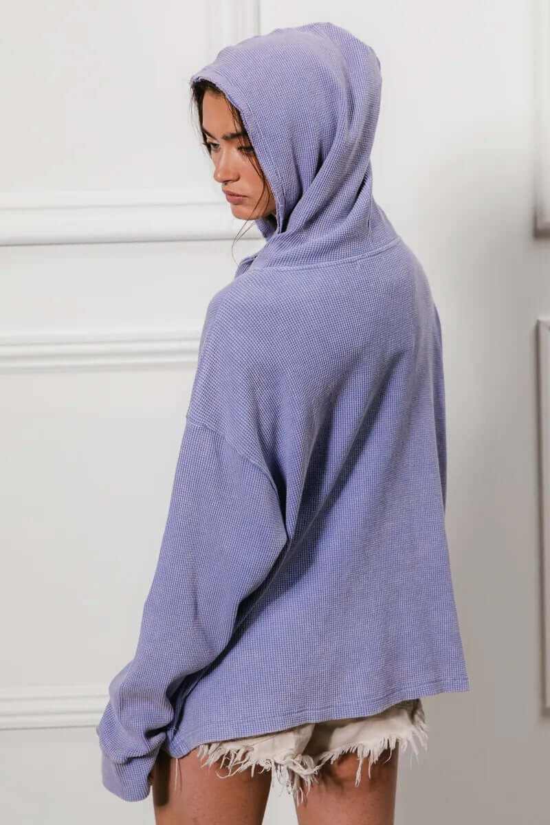 Woman wearing a lavender oversized hooded jacket with a waffle-knit texture, showcasing a cozy and stylish look.